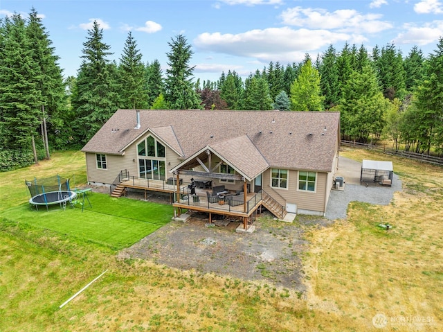 140 Bowers, Chehalis, WA 98532 - rear view of property with a trampoline, a deck, a yard, roof with shingles, and a wooded view
