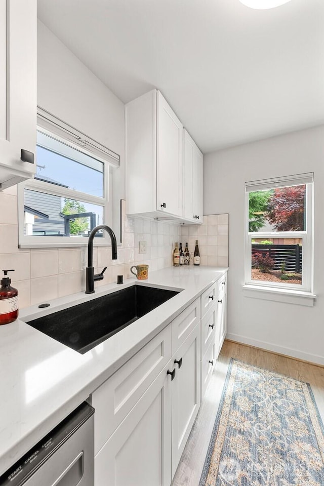 102 NW 132nd St, Seattle, WA 98177 - kitchen with stainless steel dishwasher, healthy amount of natural light, white cabinetry, and backsplash