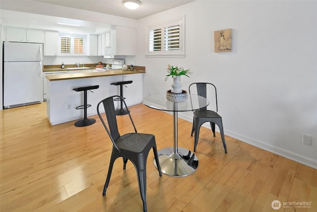 4444 44th Ave SW Unit 101, Seattle, WA 98116 - dining room with light wood finished floors and baseboards