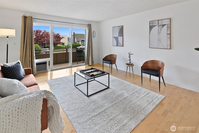 4444 44th Ave SW Unit 101, Seattle, WA 98116 - living room featuring wood finished floors and a textured ceiling