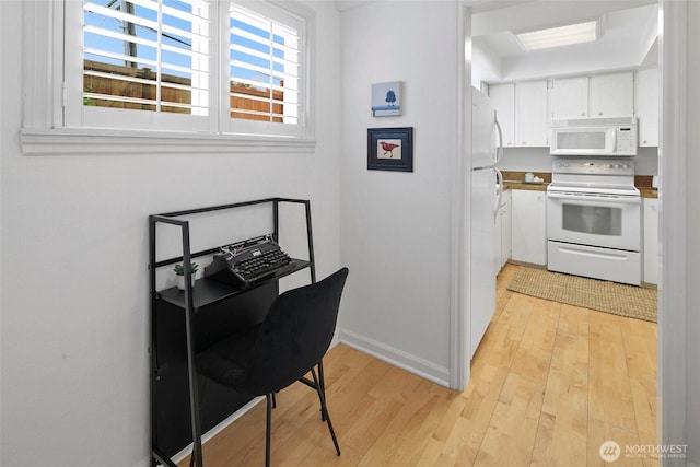 4444 44th Ave SW Unit 101, Seattle, WA 98116 - kitchen featuring white appliances, light wood-style floors, and white cabinets