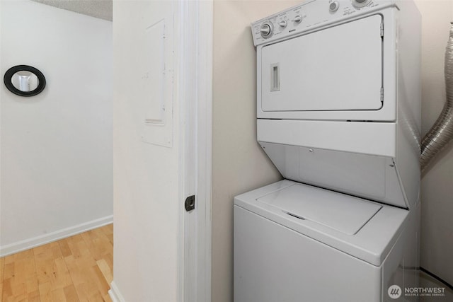 4444 44th Ave SW Unit 101, Seattle, WA 98116 - washroom featuring stacked washing machine and dryer, wood finished floors, and electric panel