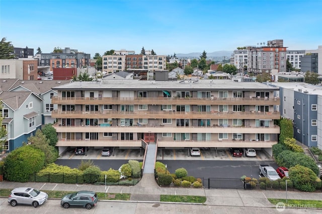 4444 44th Ave SW Unit 101, Seattle, WA 98116 - view of apartment building / complex with uncovered parking and a mountain view