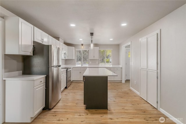1513 154th St E, Tacoma, WA 98445 - kitchen with stainless steel appliances, light countertops, white cabinetry, light wood finished floors, and recessed lighting