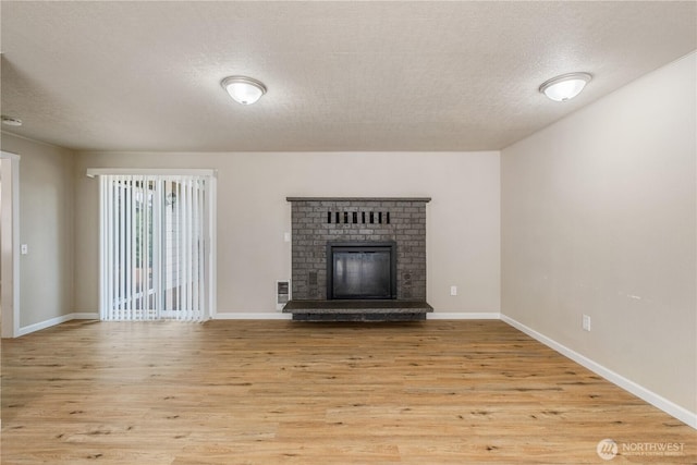 1513 154th St E, Tacoma, WA 98445 - unfurnished living room featuring wood finished floors, a textured ceiling, and a fireplace