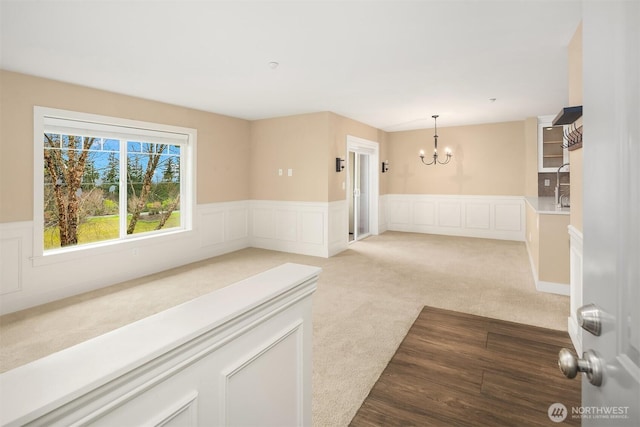 1957 23rd Pl NE Unit 201, Issaquah, WA 98029 - carpeted empty room featuring a chandelier, wainscoting, and a decorative wall