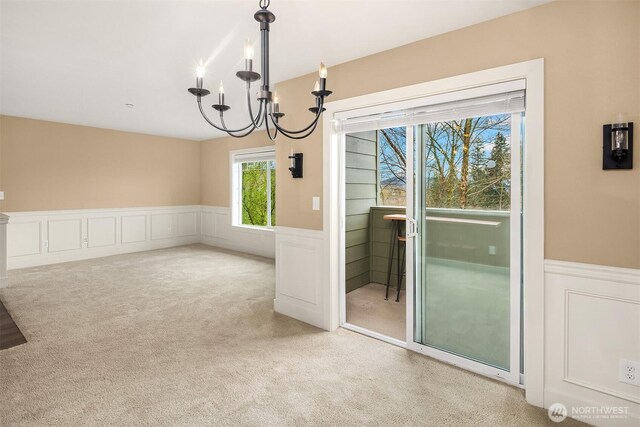 1957 23rd Pl NE Unit 201, Issaquah, WA 98029 - unfurnished dining area with a chandelier, a wainscoted wall, a decorative wall, and carpet floors