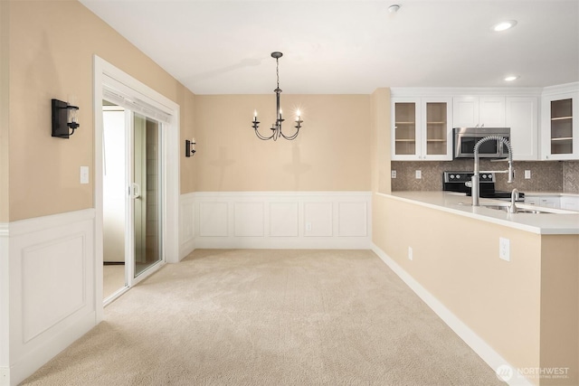 1957 23rd Pl NE Unit 201, Issaquah, WA 98029 - unfurnished dining area with light carpet, a chandelier, a wainscoted wall, recessed lighting, and a decorative wall