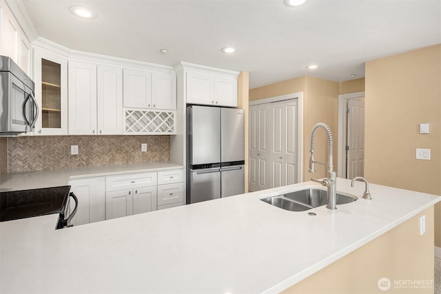 1957 23rd Pl NE Unit 201, Issaquah, WA 98029 - kitchen featuring appliances with stainless steel finishes, decorative backsplash, glass insert cabinets, white cabinets, and recessed lighting