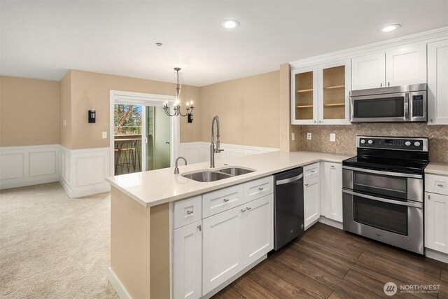 1957 23rd Pl NE Unit 201, Issaquah, WA 98029 - kitchen with appliances with stainless steel finishes, a peninsula, white cabinetry, light countertops, and a wainscoted wall
