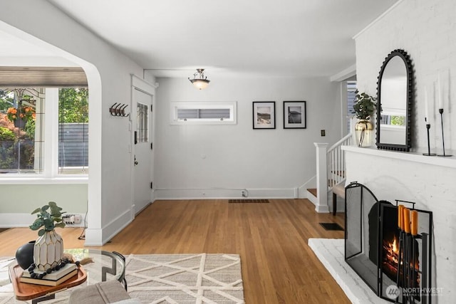 4055 SW Prince St, Seattle, WA 98116 - unfurnished living room featuring arched walkways, light wood finished floors, and stairway