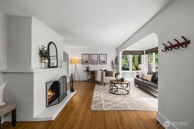 4055 SW Prince St, Seattle, WA 98116 - living room with wood finished floors, a fireplace, and arched walkways