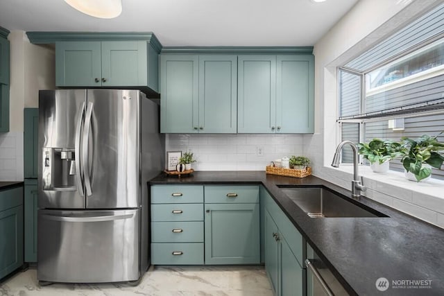 4055 SW Prince St, Seattle, WA 98116 - kitchen with stainless steel fridge with ice dispenser, light marble finish flooring, dark countertops, and backsplash