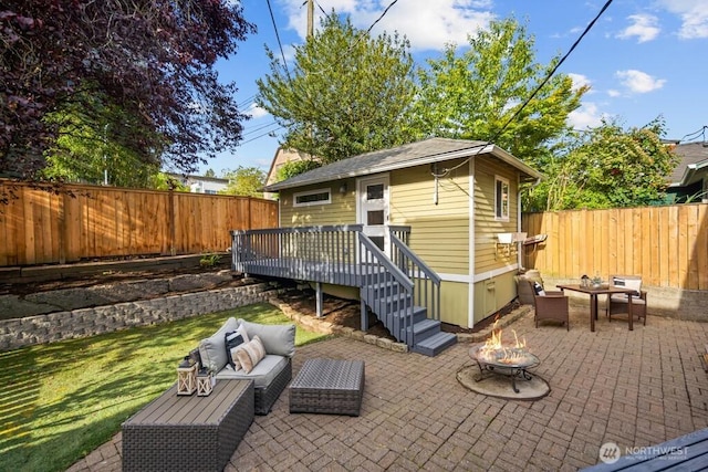 4055 SW Prince St, Seattle, WA 98116 - fenced backyard featuring an outdoor living space with a fire pit, a patio, and a deck