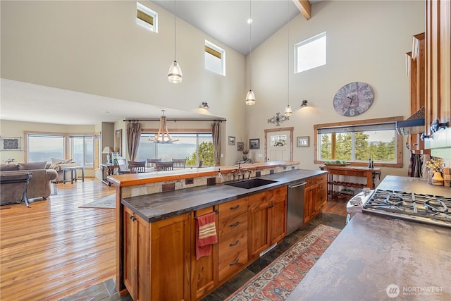 95 Horizon Ln, Chelan, WA 98816 - kitchen with dishwasher, dark wood-type flooring, a kitchen island with sink, high vaulted ceiling, and plenty of natural light