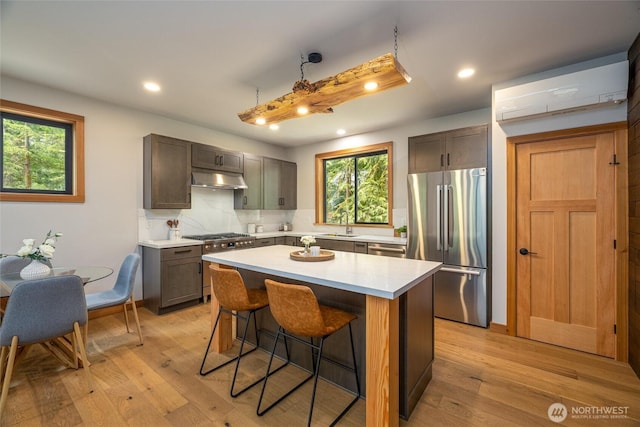 7489 Olsen Dr, Deming, WA 98244 - kitchen featuring appliances with stainless steel finishes, backsplash, a center island, a kitchen breakfast bar, and healthy amount of natural light