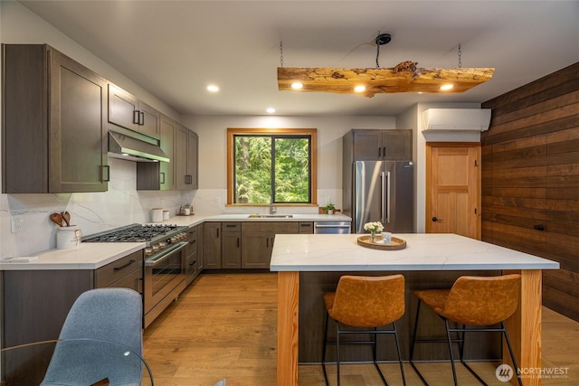 7489 Olsen Dr, Deming, WA 98244 - kitchen with premium appliances, under cabinet range hood, a kitchen bar, light stone counters, and recessed lighting