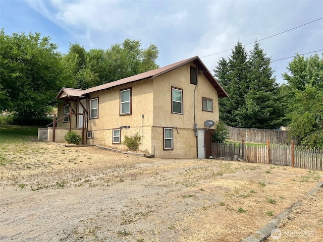 552 Maple St S, Okanogan, WA 98844 - view of side of home featuring stucco siding and a metal roof