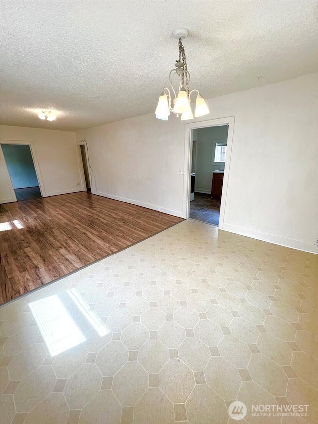 552 Maple St S, Okanogan, WA 98844 - spare room featuring a chandelier, a textured ceiling, and wood finished floors