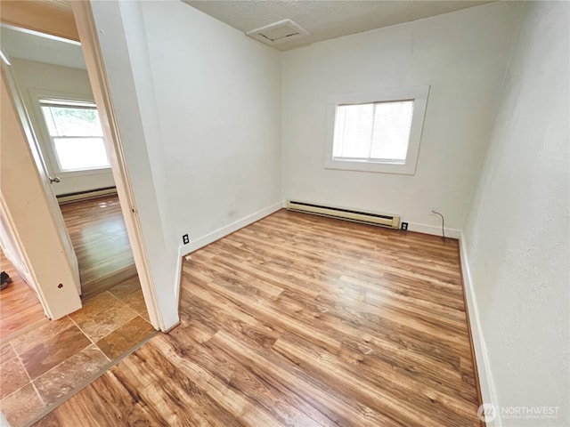 552 Maple St S, Okanogan, WA 98844 - empty room with a baseboard radiator, wood finished floors, and attic access