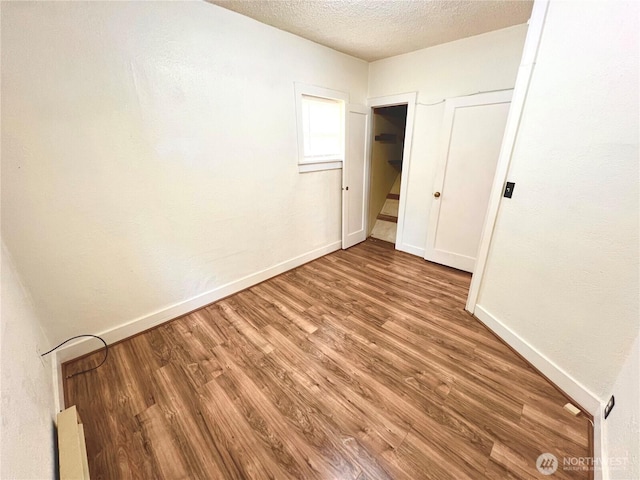 552 Maple St S, Okanogan, WA 98844 - unfurnished bedroom with wood finished floors and a textured ceiling