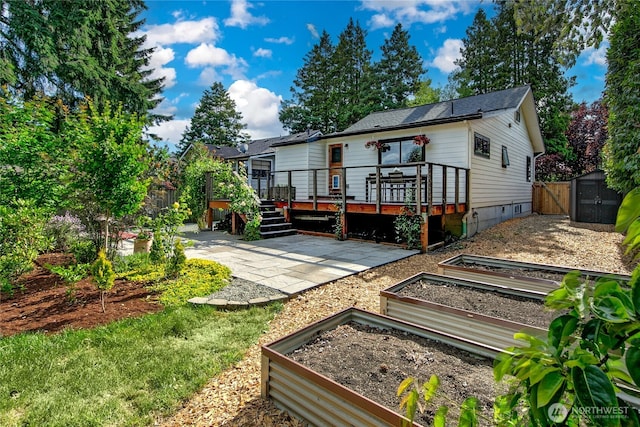 8608 12th Ave SW, Seattle, WA 98106 - rear view of property featuring a vegetable garden, a patio, a wooden deck, crawl space, and a gate