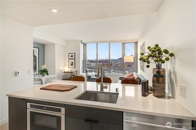 590 1st Ave S Unit 907, Seattle, WA 98104 - kitchen featuring open floor plan, light stone counters, dishwasher, modern cabinets, and oven