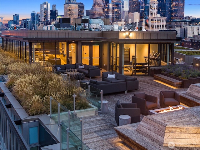 590 1st Ave S Unit 907, Seattle, WA 98104 - deck at dusk with an outdoor living space with a fire pit and a skyline view
