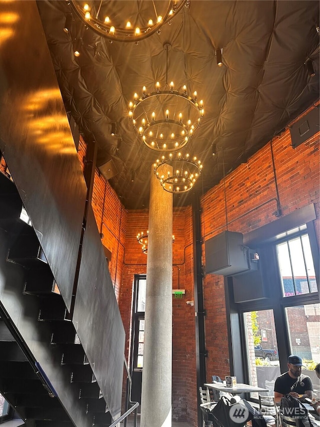 590 1st Ave S Unit 907, Seattle, WA 98104 - stairs with a high ceiling, a chandelier, and brick wall