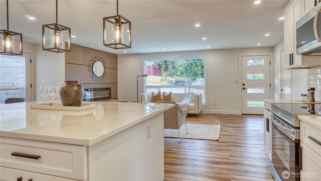840 SW 306th St, Federal Way, WA 98023 - kitchen featuring appliances with stainless steel finishes, white cabinets, light wood-style flooring, recessed lighting, and open floor plan