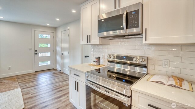 840 SW 306th St, Federal Way, WA 98023 - kitchen featuring appliances with stainless steel finishes, light wood-style floors, light countertops, recessed lighting, and backsplash