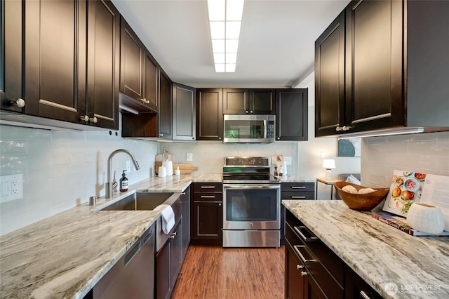 1110 E Harrison St Unit 301, Seattle, WA 98102 - kitchen with appliances with stainless steel finishes, tasteful backsplash, light stone countertops, and dark brown cabinetry