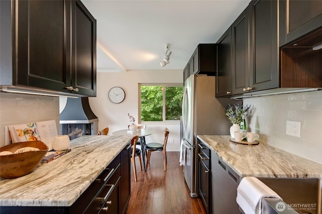 1110 E Harrison St Unit 301, Seattle, WA 98102 - kitchen featuring dark wood-style floors, backsplash, light stone counters, and stainless steel dishwasher
