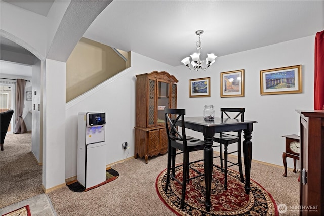 7230 178th St E, Puyallup, WA 98375 - dining room featuring light colored carpet, arched walkways, and a chandelier
