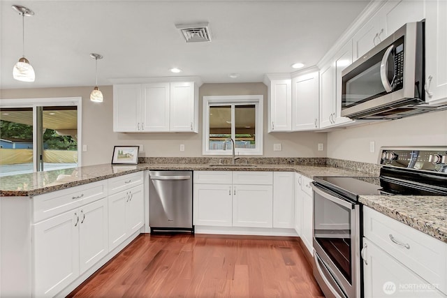 3005 Old Morse Rd SE, Olympia, WA 98501 - kitchen featuring appliances with stainless steel finishes, a peninsula, wood finished floors, white cabinets, and recessed lighting