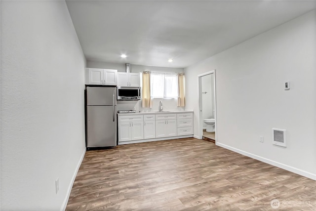 3005 Old Morse Rd SE, Olympia, WA 98501 - kitchen with stainless steel appliances, white cabinets, light wood-style flooring, light countertops, and recessed lighting