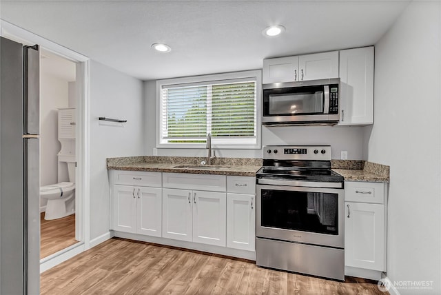 3005 Old Morse Rd SE, Olympia, WA 98501 - kitchen featuring appliances with stainless steel finishes, light wood-style floors, white cabinetry, light stone countertops, and recessed lighting