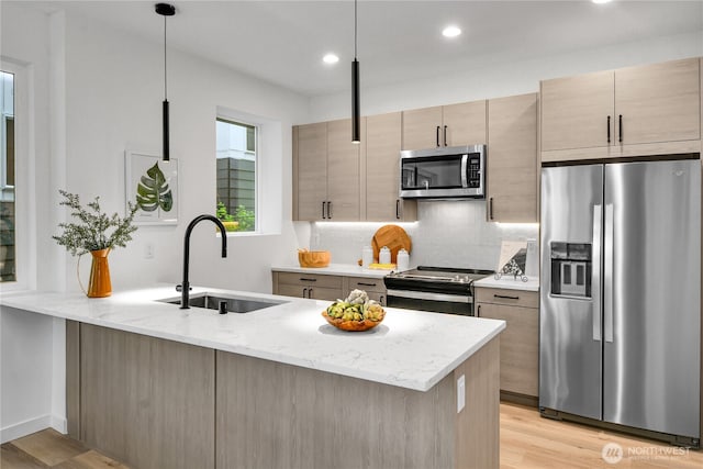 629A W Emerson Ave, Seattle, WA 98119 - kitchen with appliances with stainless steel finishes, a peninsula, light wood-type flooring, light stone countertops, and recessed lighting