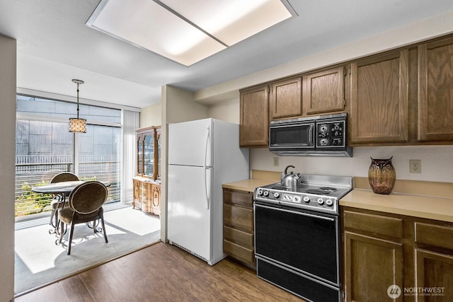 11300 1st Ave NE Unit 224, Seattle, WA 98125 - kitchen with range with electric stovetop, black microwave, freestanding refrigerator, and light countertops