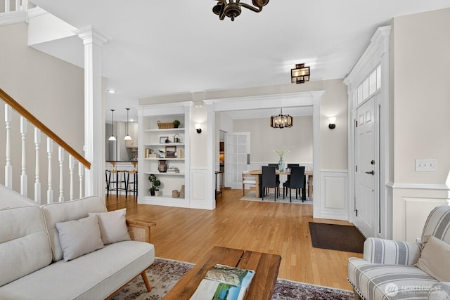 2414 42nd Pl, Anacortes, WA 98221 - living area featuring a chandelier, light wood finished floors, ornate columns, wainscoting, and built in shelves