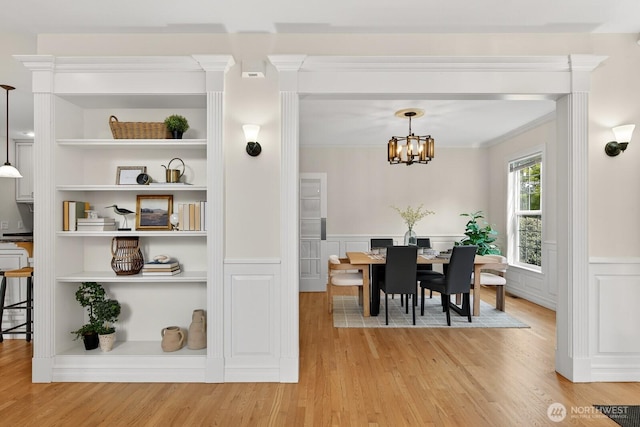 2414 42nd Pl, Anacortes, WA 98221 - dining room with light wood-style floors, wainscoting, a chandelier, crown molding, and a decorative wall