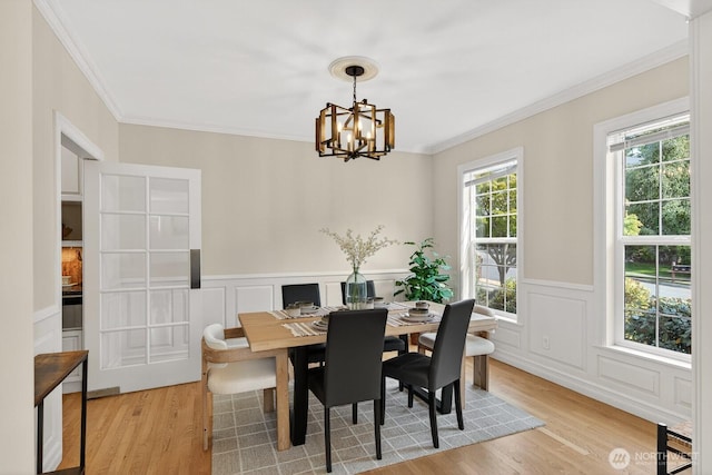 2414 42nd Pl, Anacortes, WA 98221 - dining space featuring ornamental molding, a chandelier, light wood-style flooring, a decorative wall, and wainscoting