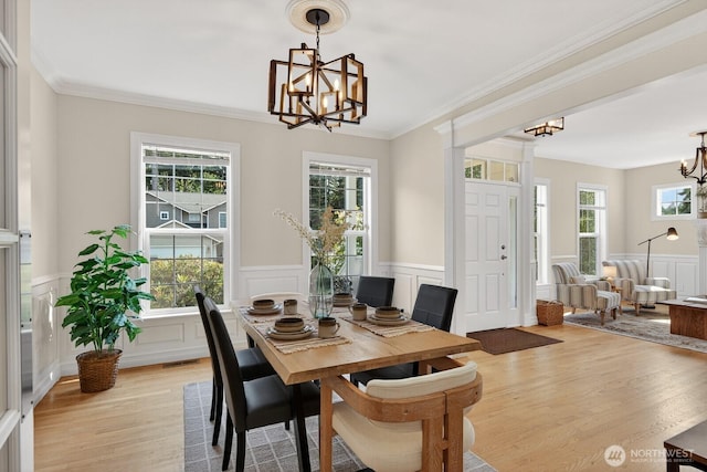 2414 42nd Pl, Anacortes, WA 98221 - dining space featuring a chandelier, a decorative wall, light wood-type flooring, a wainscoted wall, and healthy amount of natural light