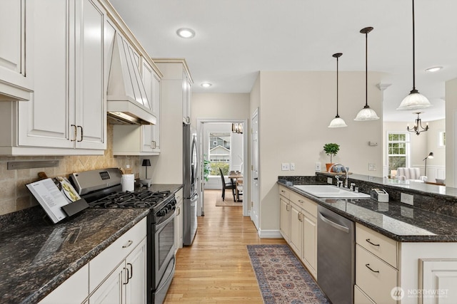 2414 42nd Pl, Anacortes, WA 98221 - kitchen featuring stainless steel appliances, a peninsula, light wood-style flooring, tasteful backsplash, and custom exhaust hood