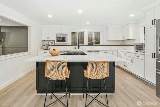 17519 33rd Ave NE, Lake Forest Park, WA 98155 - kitchen with built in microwave, stainless steel gas cooktop, light wood-style floors, white cabinetry, and recessed lighting