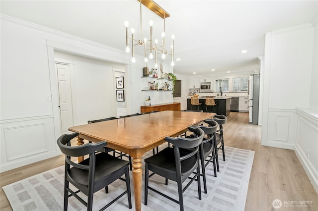 17519 33rd Ave NE, Lake Forest Park, WA 98155 - dining area featuring light wood finished floors, a chandelier, recessed lighting, a decorative wall, and ornamental molding