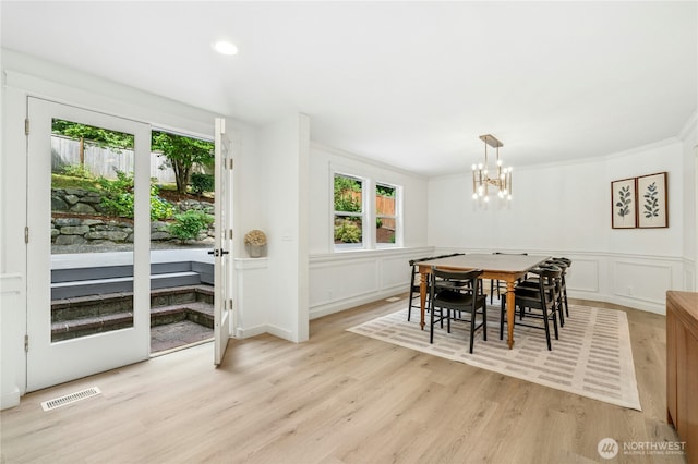 17519 33rd Ave NE, Lake Forest Park, WA 98155 - dining space featuring a chandelier, light wood-type flooring, a decorative wall, ornamental molding, and a wainscoted wall