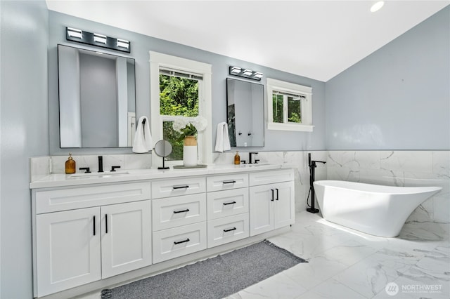 17519 33rd Ave NE, Lake Forest Park, WA 98155 - bathroom with marble finish floors, double vanity, a freestanding bath, tile walls, and wainscoting
