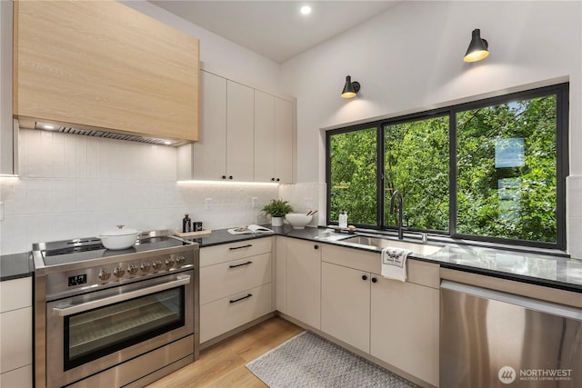 11029 84th Ave S, Seattle, WA 98178 - kitchen featuring stainless steel appliances, tasteful backsplash, light wood-style floors, dark countertops, and recessed lighting