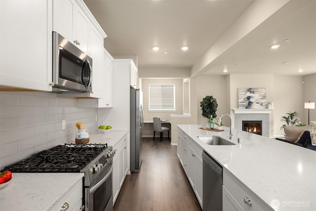 1312 Baker Heights Loop, Bremerton, WA 98312 - kitchen featuring appliances with stainless steel finishes, open floor plan, white cabinets, light stone countertops, and recessed lighting